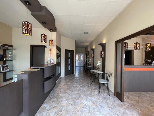 a hallway with a dining room with a table at Alfa Hotel in Győr