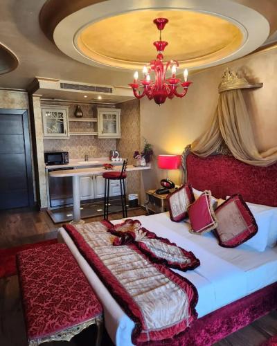 a bedroom with a large bed and a chandelier at Q Hotel in Beirut