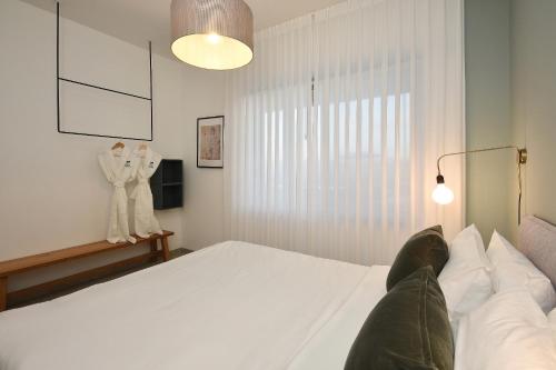 a bedroom with a large white bed and a window at וילה אלטה בוטיק - לנפוש בארץ להרגיש בחו"ל in Mishmār Hāyardin