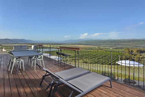 a patio with a table and chairs on a deck at וילה אלטה בוטיק - לנפוש בארץ להרגיש בחו"ל in Mishmār Hāyardin