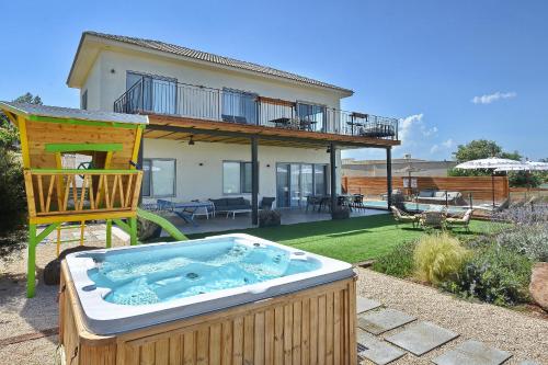 a house with a hot tub in a yard at וילה אלטה בוטיק - לנפוש בארץ להרגיש בחו"ל in Mishmār Hāyardin