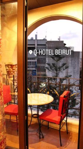 a table and chairs in a room with a window at Q Hotel in Beirut