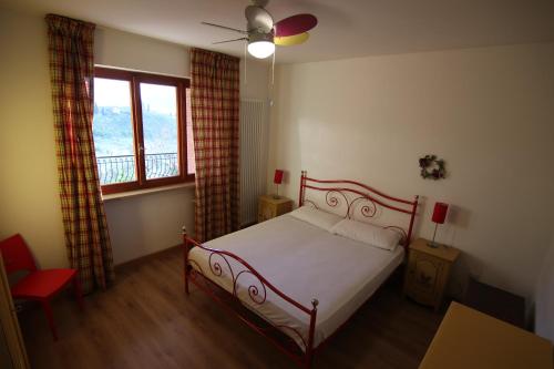 1 dormitorio con cama y ventana en red house apartments whit enchanting lake view, en Malcesine