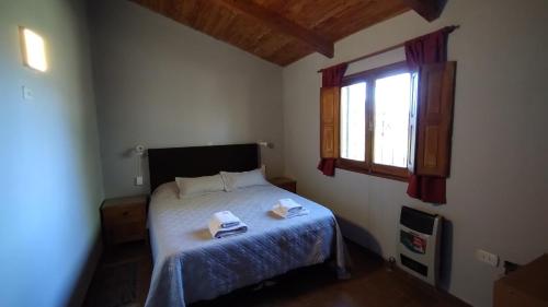 a bedroom with a bed with two towels on it at Casa en Tafí del Valle in Tafí del Valle