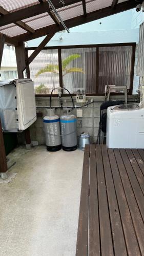 a patio with three trash cans and a bench at Okinawa Naha JinJin -沖縄伝統体験型宿じんじん- in Naha