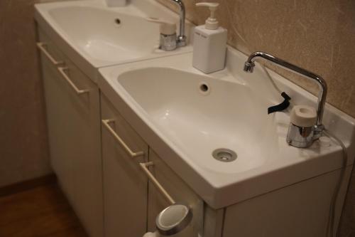 a white bathroom sink with a faucet above it at Guest House Tokyo Samurai in Tokyo