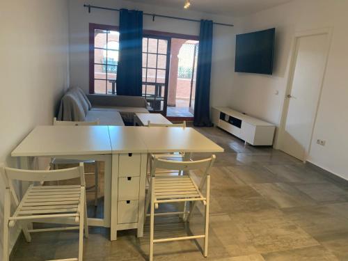 サン・フェルナンドにあるAPTO BAHIA SUR RESERVA DE CONFIANZAのテーブル、椅子、ベッドが備わる客室です。