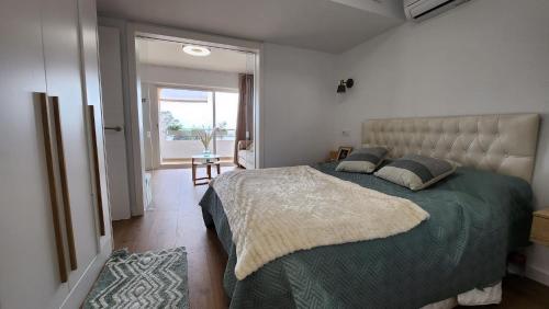 a bedroom with a large bed with a green comforter at Mediterranean apartment Rosas in Roses