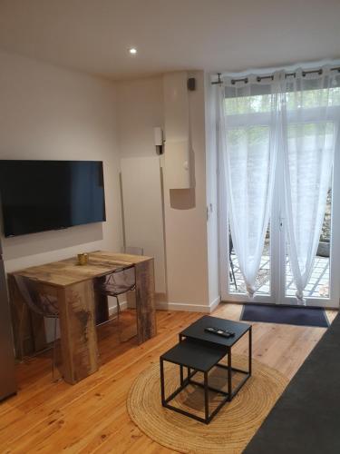 a living room with a desk and a large window at Appartement chic et cosy in Authézat