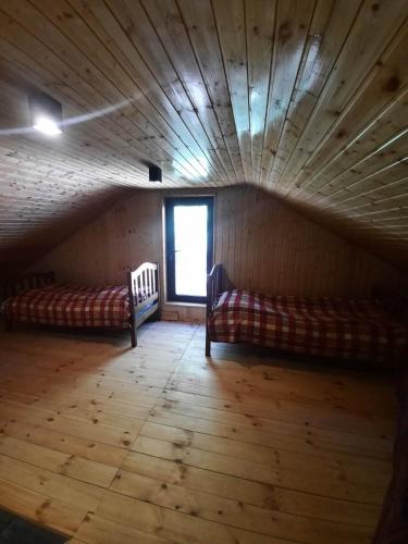 an attic room with two beds and a window at Dali Guest House in Oni