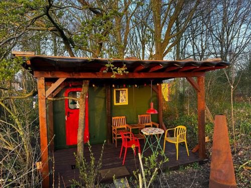 cabina con mesa y sillas en la cubierta en Eco-Camping De Helleborus, Yurt, Bell & Safari tent, Pipo, Caravans, Dorms and Units, en Groninga
