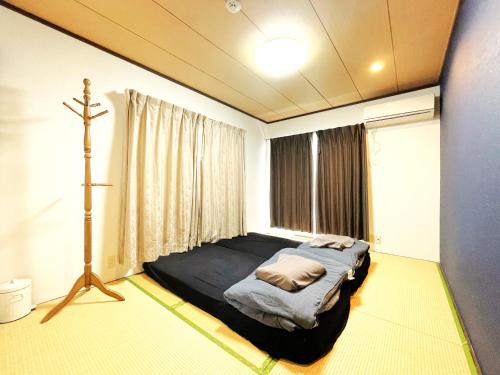 a bedroom with a bed and a cross on the floor at Estate F 201 in Kamatachō