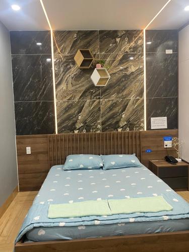 a bed in a room with a wall at Cherry Hotel Bến Lức in Bến Lức