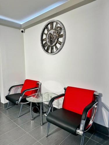 two chairs and a table and a clock on a wall at Super 8 by Wyndham Peoria in Peoria