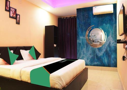 Schlafzimmer mit einem Bett und einem Spiegel an der Wand in der Unterkunft Goroomgo Luxury Star Inn Near Sum Hospital in Bhubaneshwar
