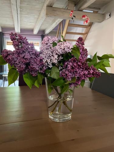 a vase filled with purple flowers sitting on a table at La grange de Sophie in Berstett