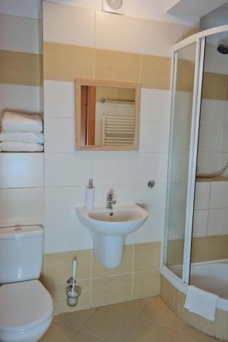 a bathroom with a toilet and a sink and a shower at Willa Centrum in Supraśl