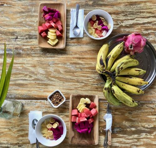 een tafel met fruitschalen en een schaal bananen bij Omala Village Gili Air in Gili Air