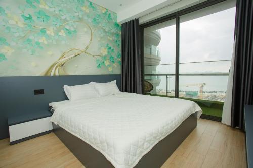 1 dormitorio con 1 cama y un mural de flores en Citadines Marina HaLong 1908, en Ha Long