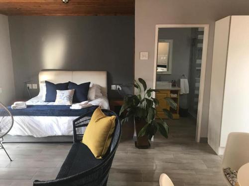 een slaapkamer met een bed met blauwe en gele kussens bij Blue Lotus Guest House Pta East-No Loadshedding in Pretoria