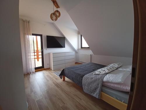 a small bedroom with a bed and a television at Chillout House Serwy in Serwy