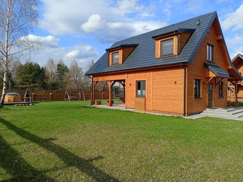 a large wooden house with a large yard at Chillout House Serwy in Serwy