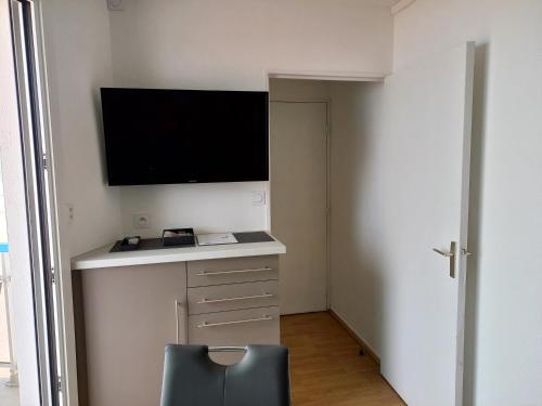 Zimmer mit einem Schreibtisch, einem TV und einem Stuhl in der Unterkunft Balcon sur mer in Saint-Gilles-Croix-de-Vie