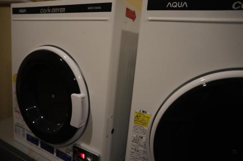 a washing machine with a window on the side of it at Guest House Tokyo Samurai in Tokyo