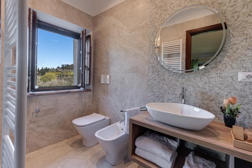 a bathroom with a sink and a toilet and a mirror at Agriturismo Nobile in Montepulciano