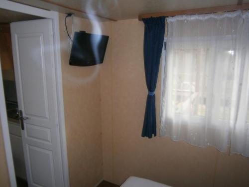 a room with a window with a blue curtain at Camping Klaus in Cavallino-Treporti
