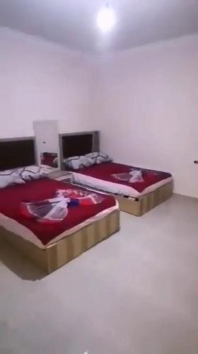2 bedden in een witte kamer met: bij القاهره in El-Sa`âida