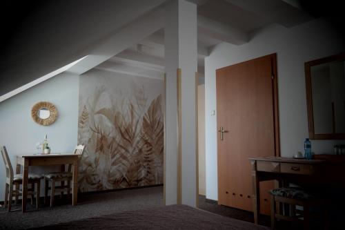 a dining room with a table and a painting on the wall at Willa Centrum in Supraśl