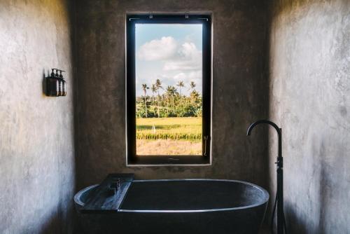 a bath tub in a bathroom with a window at Beach 600M - Designer Villas - Perenenean - Private Pool in Canggu