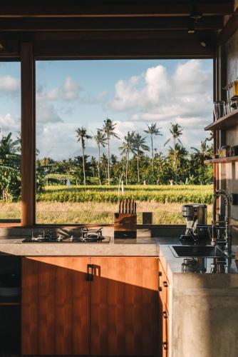 a kitchen with a large window looking out at a field at Beach 600M - Designer Villas - Perenenean - Private Pool in Canggu
