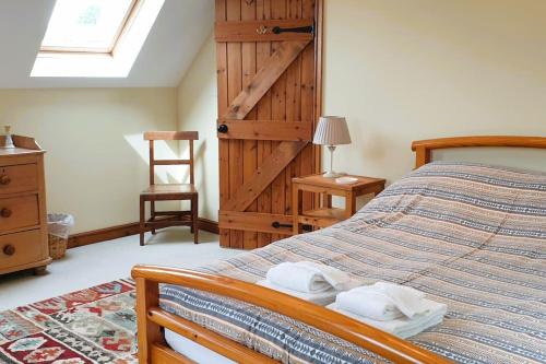a bedroom with a bed with two towels on it at Cae Coryn Cottages, Snowdonia ( Troed y Graig ) in Bala
