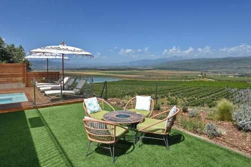 a patio with a table and two chairs and an umbrella at THE ALTA GALILEA - 3BRM WITH POOl in Mishmār Hāyardin