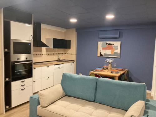 a living room with a blue couch and a kitchen at Nuevo apartamento céntrico playa de cullera. in Cullera