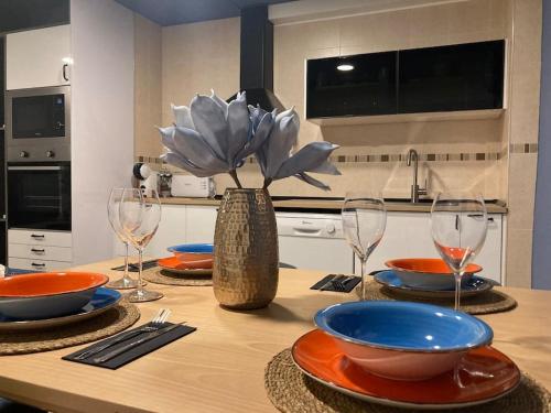 a kitchen with a table with plates and wine glasses at Nuevo apartamento céntrico playa de cullera. in Cullera