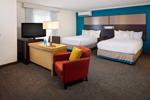 a hotel room with two beds and a chair and a television at Residence Inn Cherry Hill Philadelphia in Cherry Hill