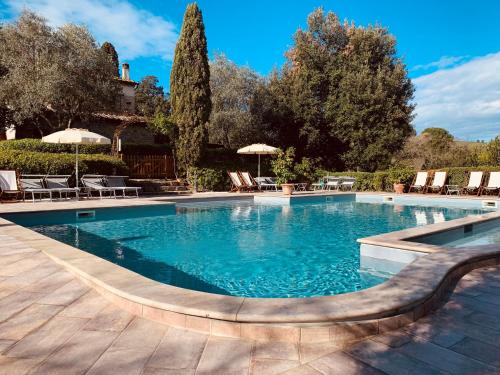 una gran piscina con sillas y sombrillas en GHIZZOLO Residence - Refurbished 2024, en Montaione