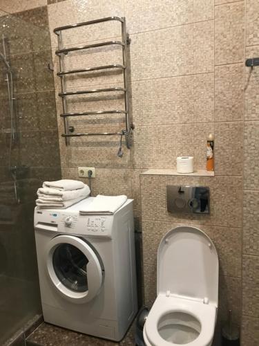 a bathroom with a washing machine and a toilet at Apart Plaza 24 in Kyiv