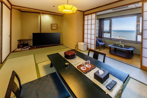 a living room with a table and a view of the ocean at 銚子グランドホテル in Choshi
