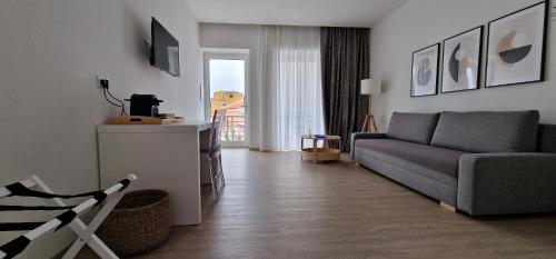 a living room with a couch and a television at SARDINIA SUITES & APARTMENTS -Suite in centro- in Santa Teresa Gallura