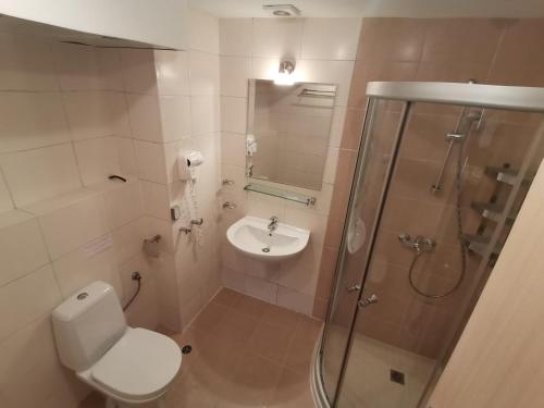 een badkamer met een douche, een toilet en een wastafel bij Obzor Beach Resort Beachfront in Obzor