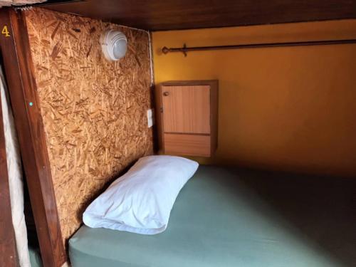 a small room with a bed and a door at Chiangmai Delight Hostel in Chiang Mai