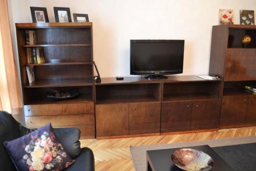 una sala de estar con TV en un centro de entretenimiento de madera en Lidda Apartment in residential area en Varna
