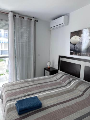 a bedroom with a bed with a blue towel on it at Riviera Mont Roig Del Camp in Tarragona