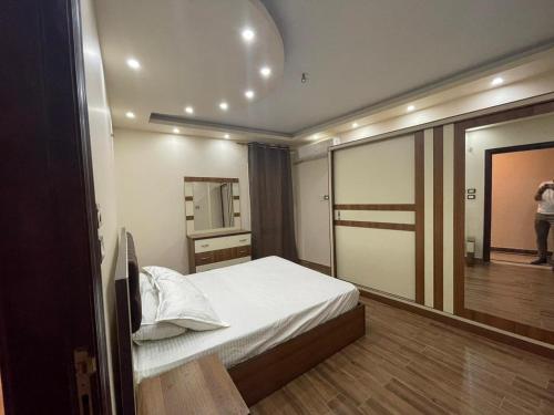 ein Schlafzimmer mit einem Bett und einem großen Spiegel in der Unterkunft Pyramids view private apartment in Kairo