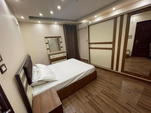 ein kleines Schlafzimmer mit einem Bett und einem Spiegel in der Unterkunft Pyramids view private apartment in Kairo