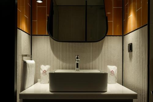 W łazience znajduje się umywalka i lustro. w obiekcie Dostyk Business Hotel w mieście Aktau